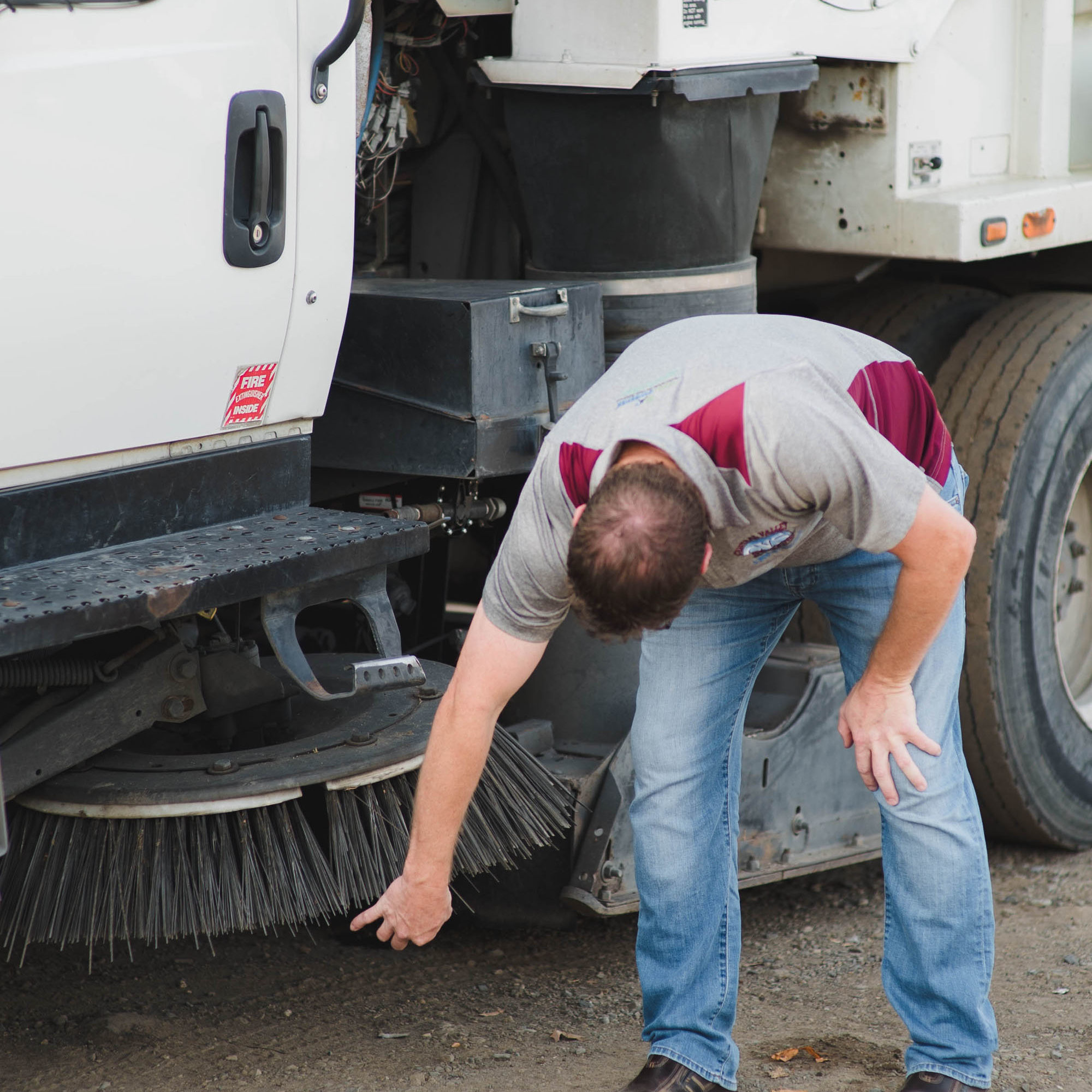 Image: A CVS employee adjusting a sweeper. Learn more about industrial sweeping.